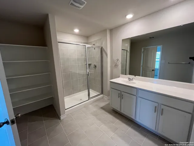 a bathroom with a shower sink and mirror