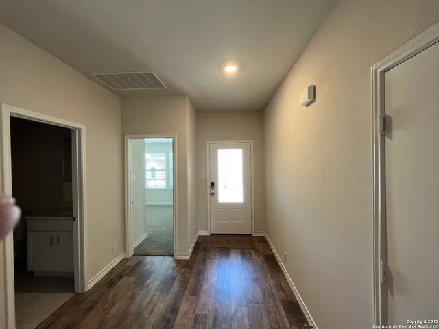 a view of a hallway with wooden floor and closet