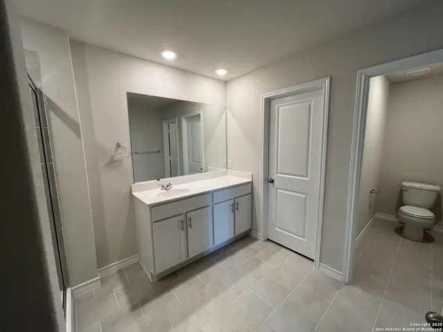 a bathroom with a sink and mirror with shower