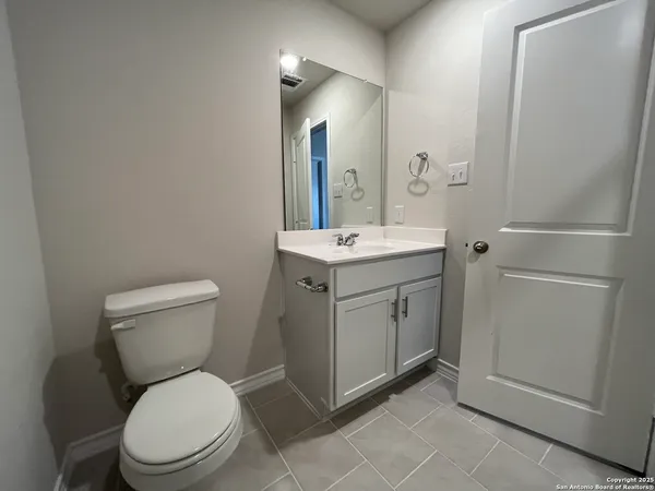 a spacious bathroom with a toilet a sink and mirror