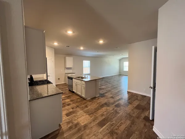 a kitchen with kitchen island a counter top space a sink a refrigerator and a stove