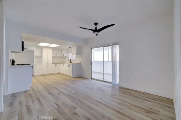 a view of a kitchen with wooden floor and a window