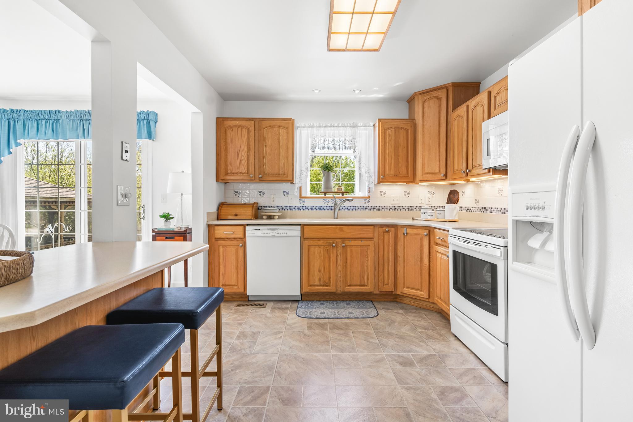 7866 Kings Bench Place Pasadena, MD 21122 - Photo 21 of 51 a kitchen with a stove a sink and a refrigerator