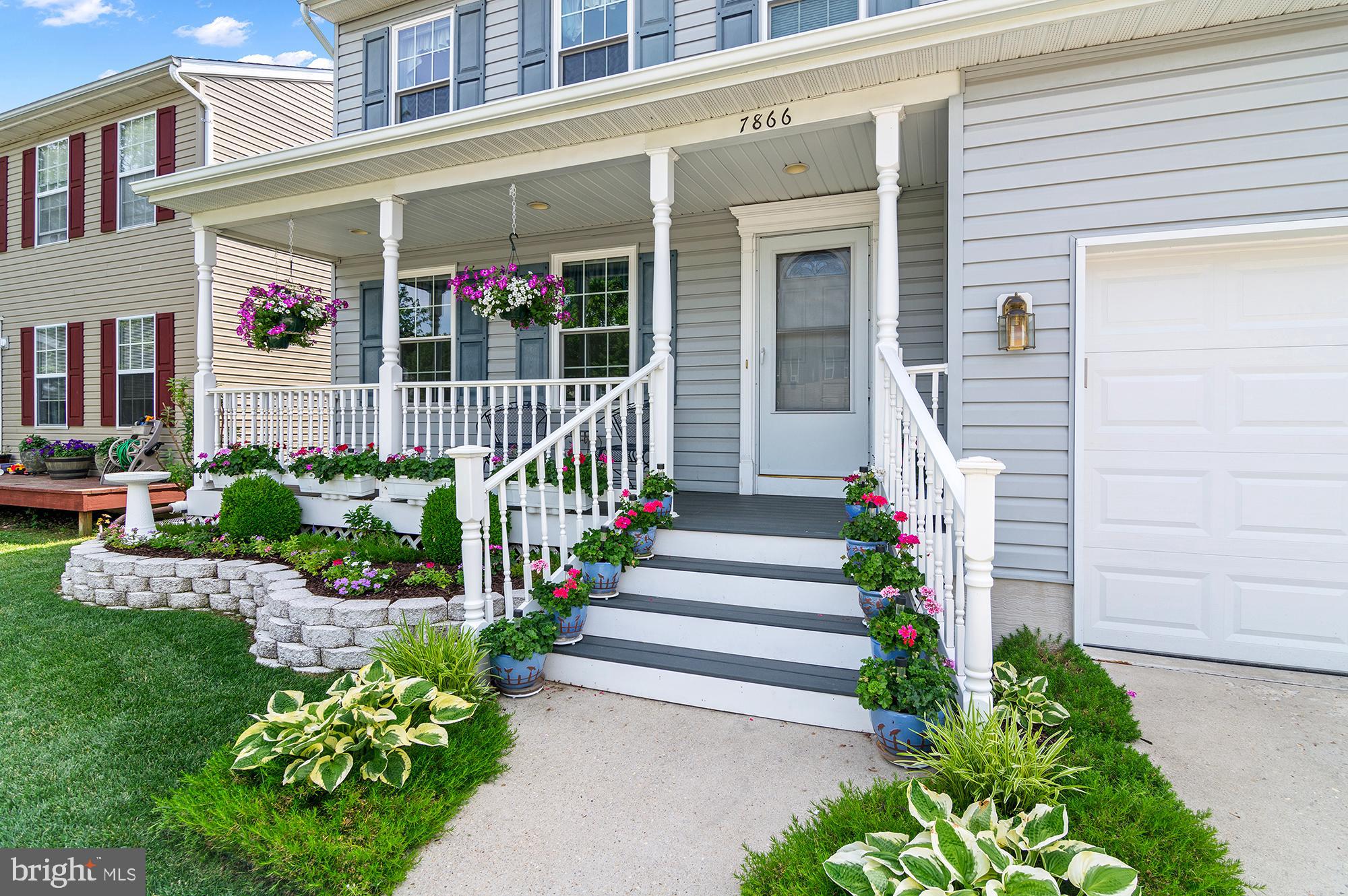7866 Kings Bench Place Pasadena, MD 21122 - Photo 4 of 51 a view of a house with large windows and flower plants