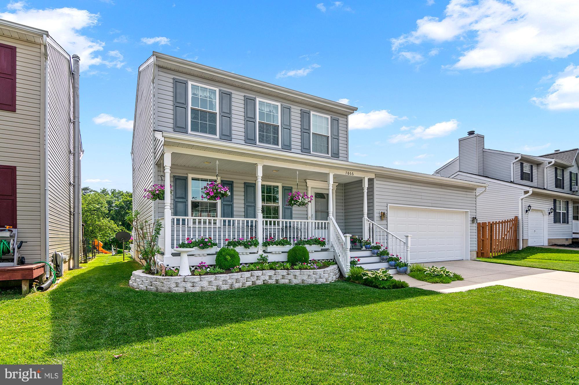 7866 Kings Bench Place Pasadena, MD 21122 - Photo 6 of 51 a front view of a house with a garden and yard