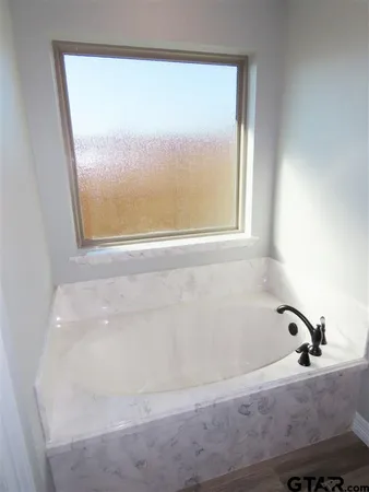 a view of a utility room with wooden floor and cabinets