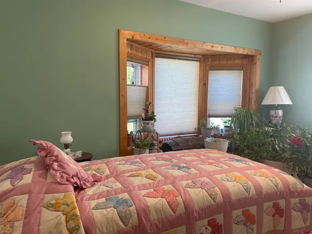 a bedroom with a bed and a potted plant