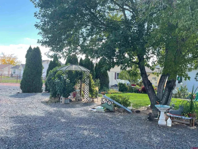 a view of a chair and table in backyard of the house