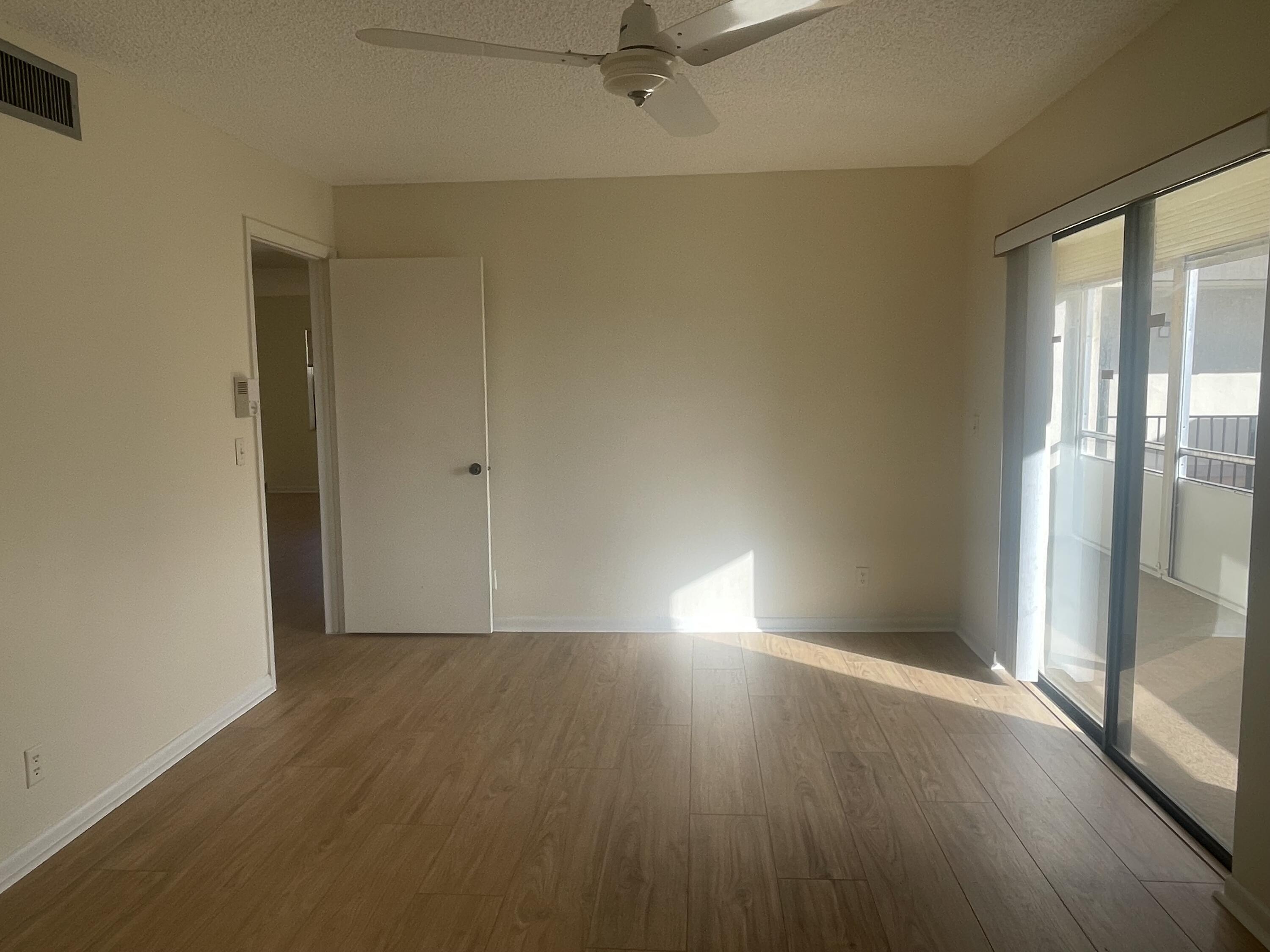 83 Capri B, Unit B Delray Beach, FL 33484 - Photo 10 of 26 an empty room with wooden floor and windows