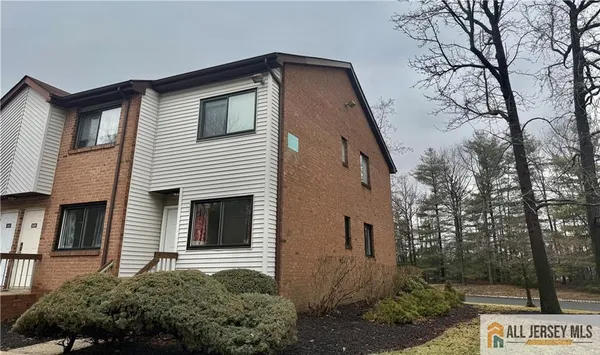 a front view of a house with a yard and tree s