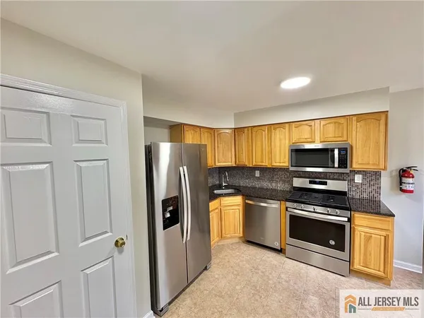 a kitchen with stainless steel appliances a stove a microwave and a refrigerator