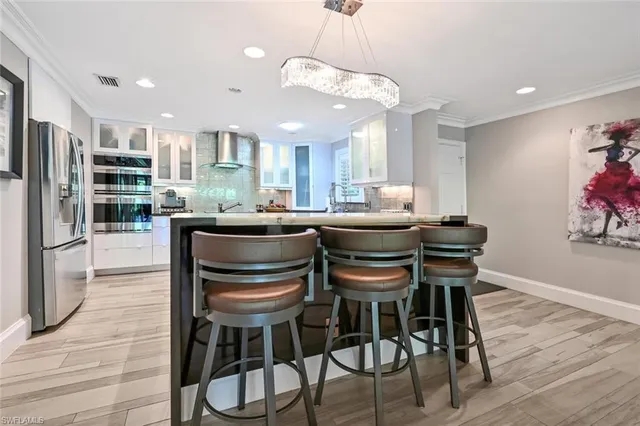 a dining room with furniture a large window and stainless steel appliances