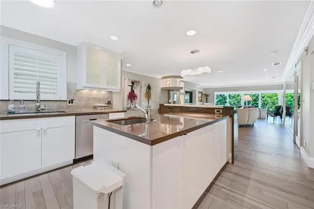 a kitchen with stainless steel appliances granite countertop a sink and a wooden floors