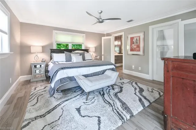 a living room with furniture a large window and wooden floor