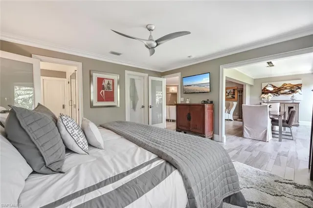 a bedroom with a large bed a flat tv screen and dresser