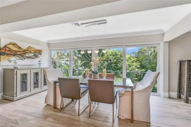 a dining room with furniture window and wooden floor