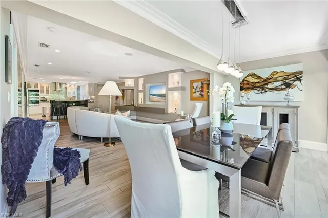 a view of a dining room with furniture a chandelier and wooden floor