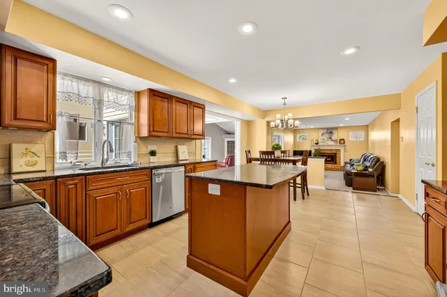 a large kitchen with stainless steel appliances granite countertop a stove refrigerator and a sink