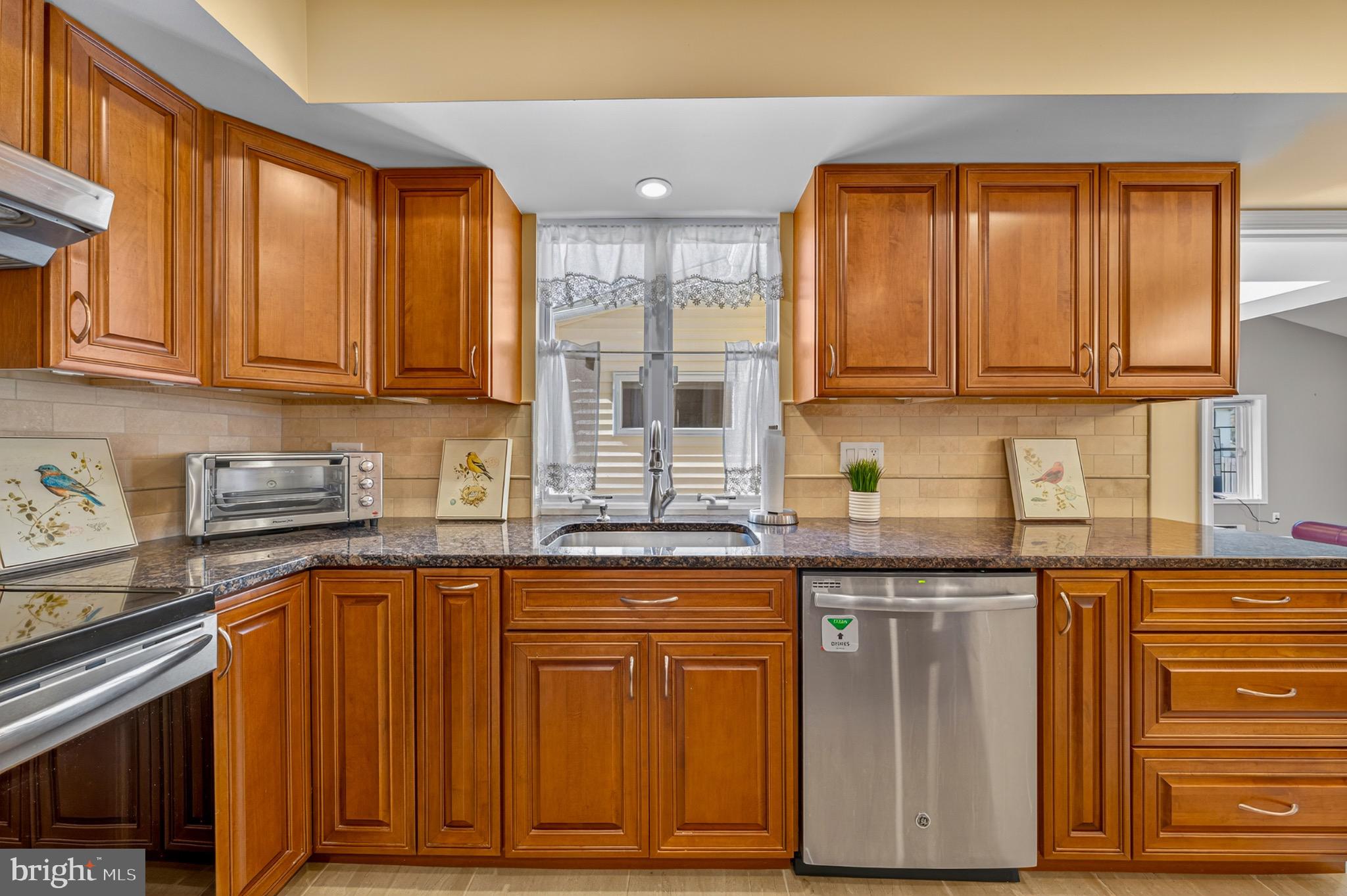1520 Fairgrounds Road Hatfield, PA 19440 - Photo 16 of 52 a kitchen with granite countertop wooden cabinets stainless steel appliances a sink and a window