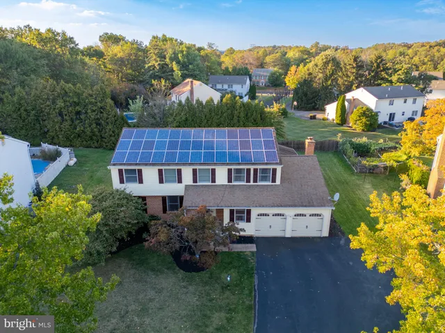 an aerial view of a house with table and chairs under an umbrella