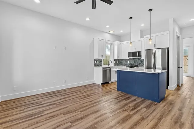 a kitchen with stainless steel appliances kitchen island wooden cabinets and fireplace