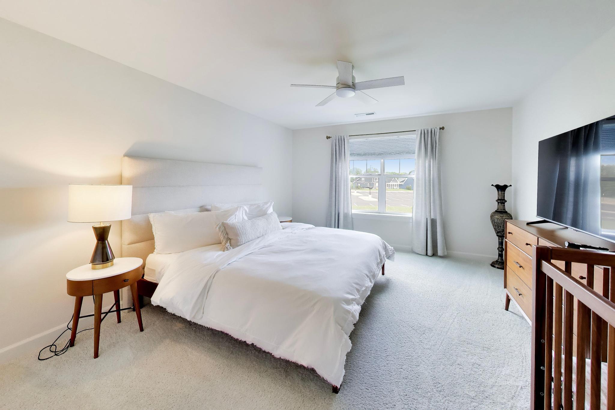 2730 Harbor Court Delavan, WI 53115 - Photo 34 of 47 Upper-level bedroom with ceiling fan, large window, carpeted floor, and Harbor Club neighborhood view.