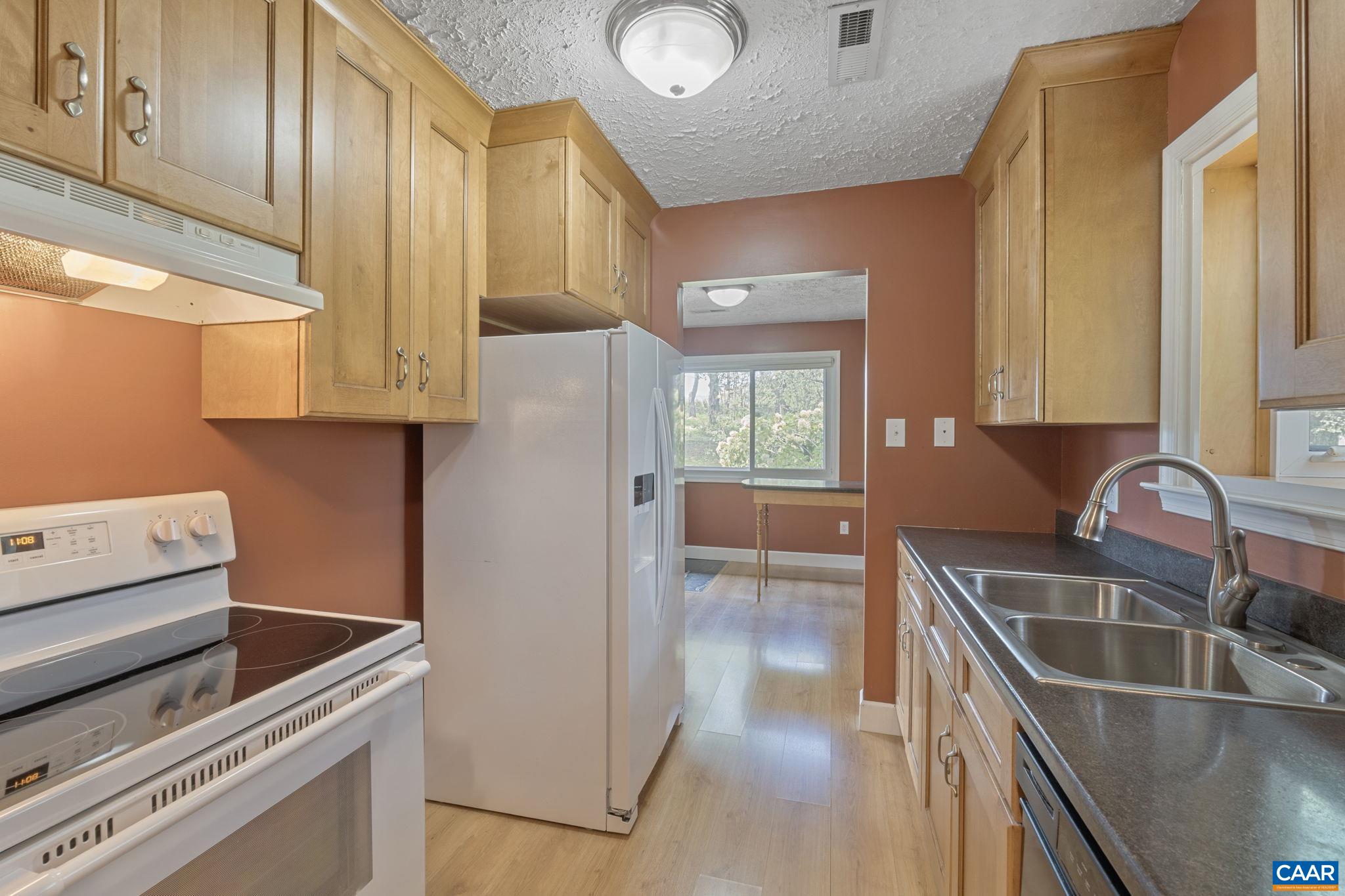 8508 Dick Woods Road Afton, VA 22920 - Photo 20 of 55 a kitchen with stainless steel appliances granite countertop a sink and a stove next to a window