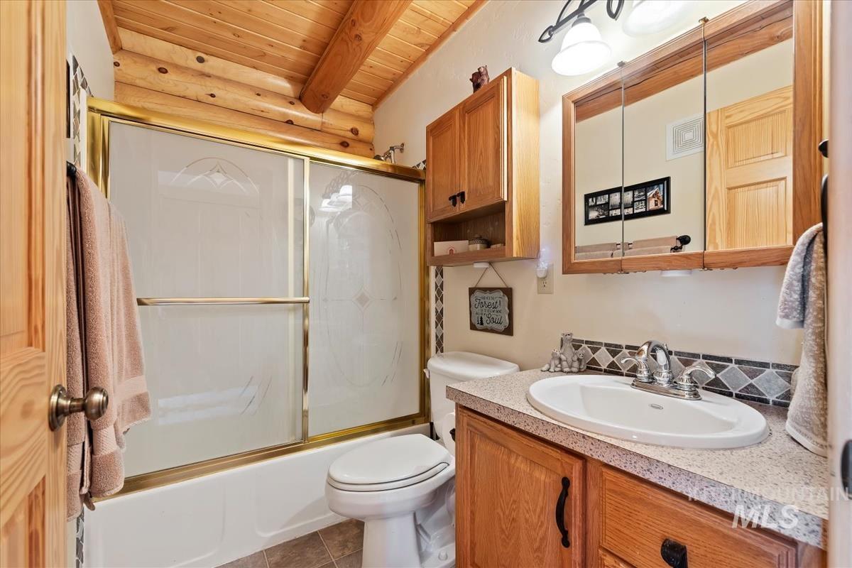 10 Elk Point Road Garden Valley, ID 83622 - Photo 22 of 42 Full bath with vanity, enclosed tub / shower combo, and a wood ceiling with exposed beams