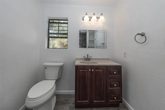 a bathroom with a toilet a sink and mirror