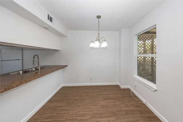 a view of a kitchen with a sink and wooden floor