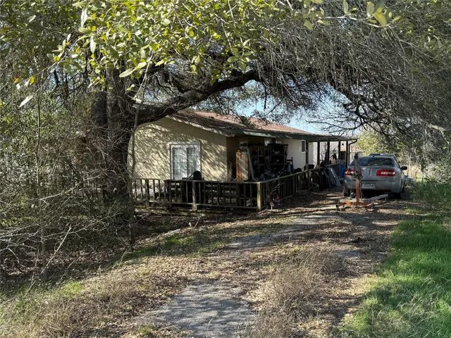 a view of a house with a tree on the road