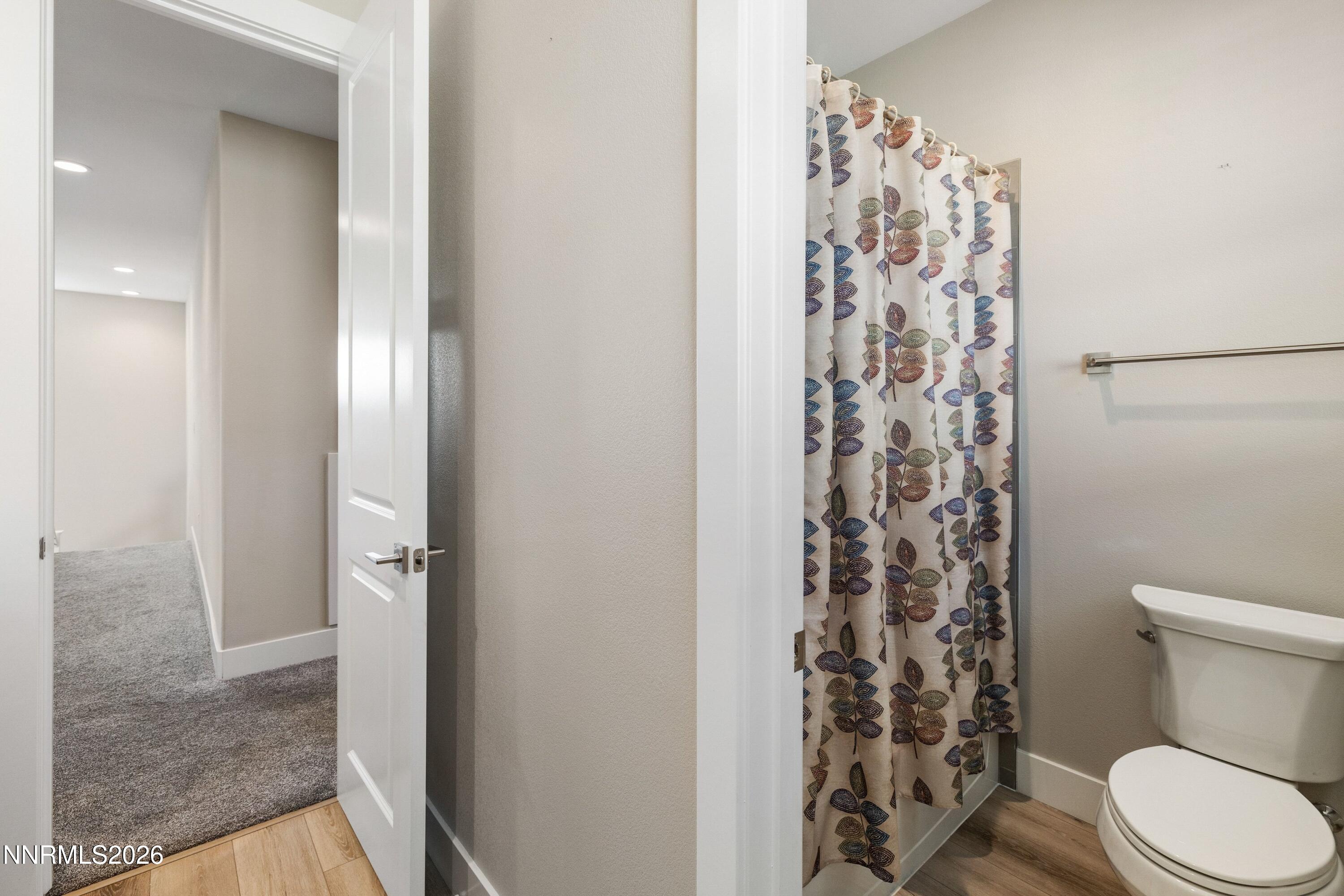 250 Commodore Drive Verdi, NV 89439 - Photo 26 of 49 a white toilet sitting next to a shower curtain