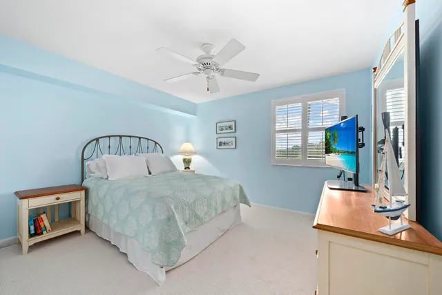 a bedroom with a large bed and a flat tv screen on dresser