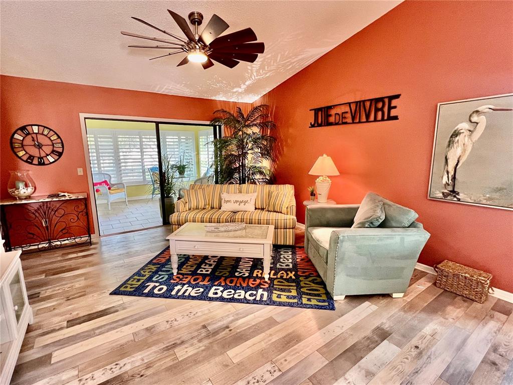 2150 Elm Street, Unit 605 Dunedin, FL 34698 - Photo 24 of 55 a living room with furniture a flat screen tv and a table
