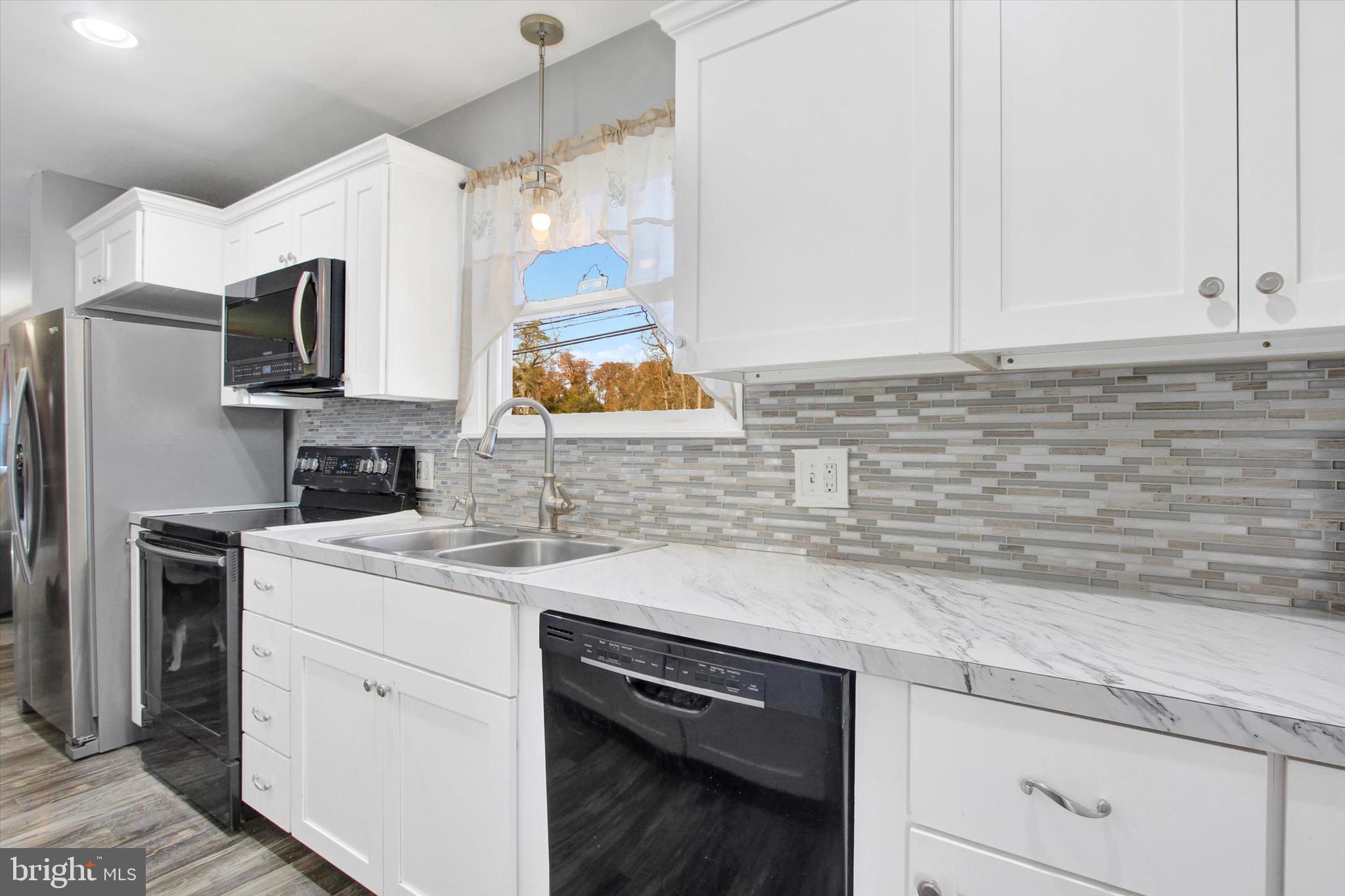 1365 Hanover Road Gettysburg, PA 17325 - Photo 11 of 26 a kitchen with a sink dishwasher a stove and a refrigerator with wooden floor