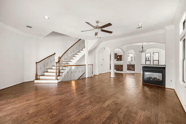 a view of a livingroom with a fireplace a chandelier and wooden floor