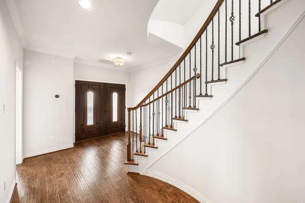 a view of a hallway with wooden floor and entryway