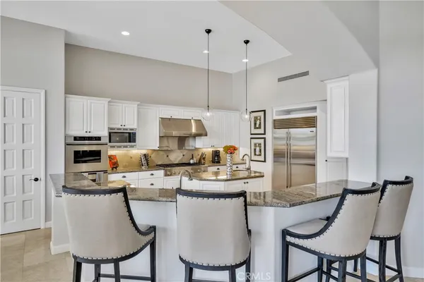 a kitchen with refrigerator and chairs