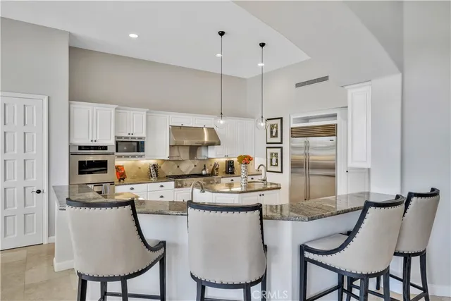 a kitchen with refrigerator and chairs