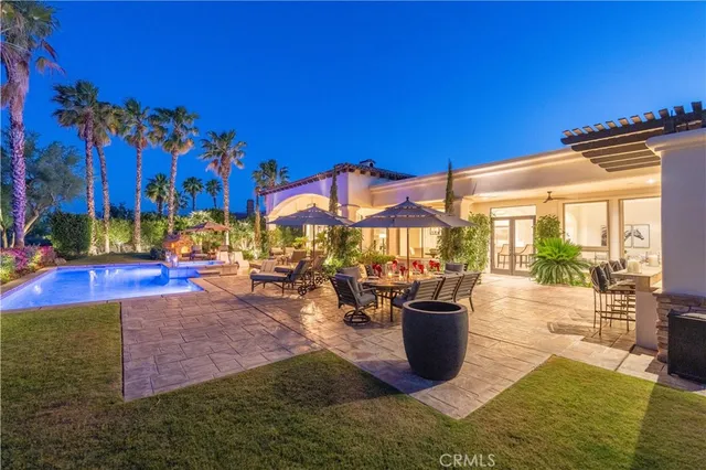 a view of a house with backyard and sitting area