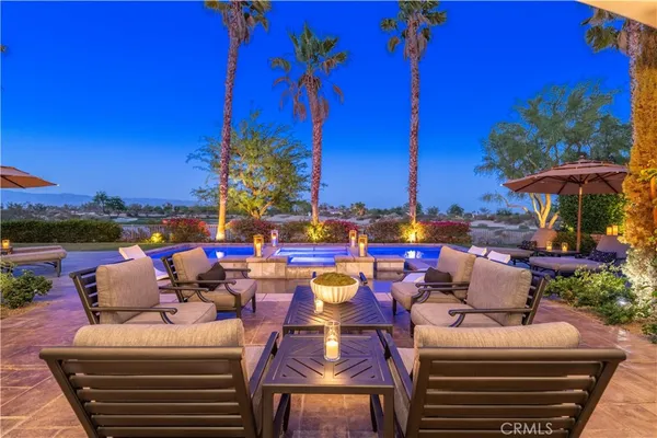 a view of a chairs and table in patio with swimming pool