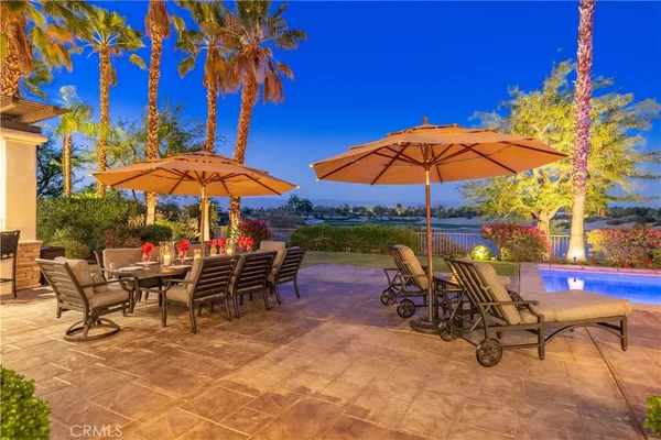a view of a chairs and table under an umbrella in backyard