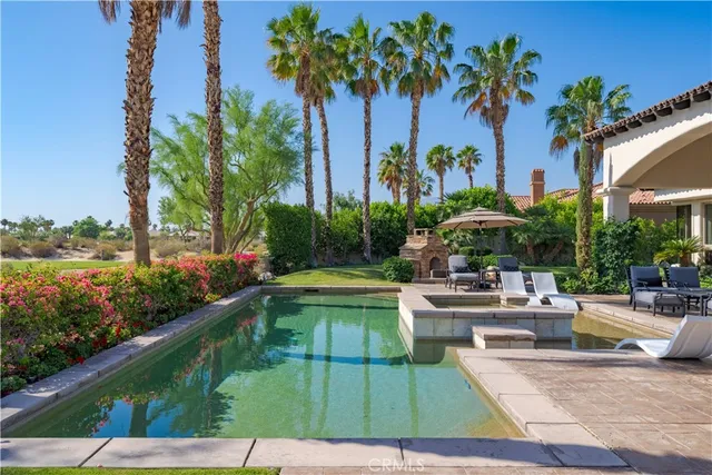 a view of a swimming pool with a garden and seating area
