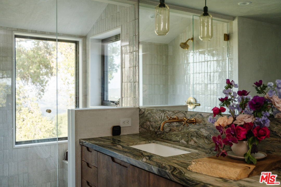 2002 Tuna Canyon Road Topanga, CA 90290 - Photo 42 of 70 a bathroom with a granite countertop sink a mirror and a shower