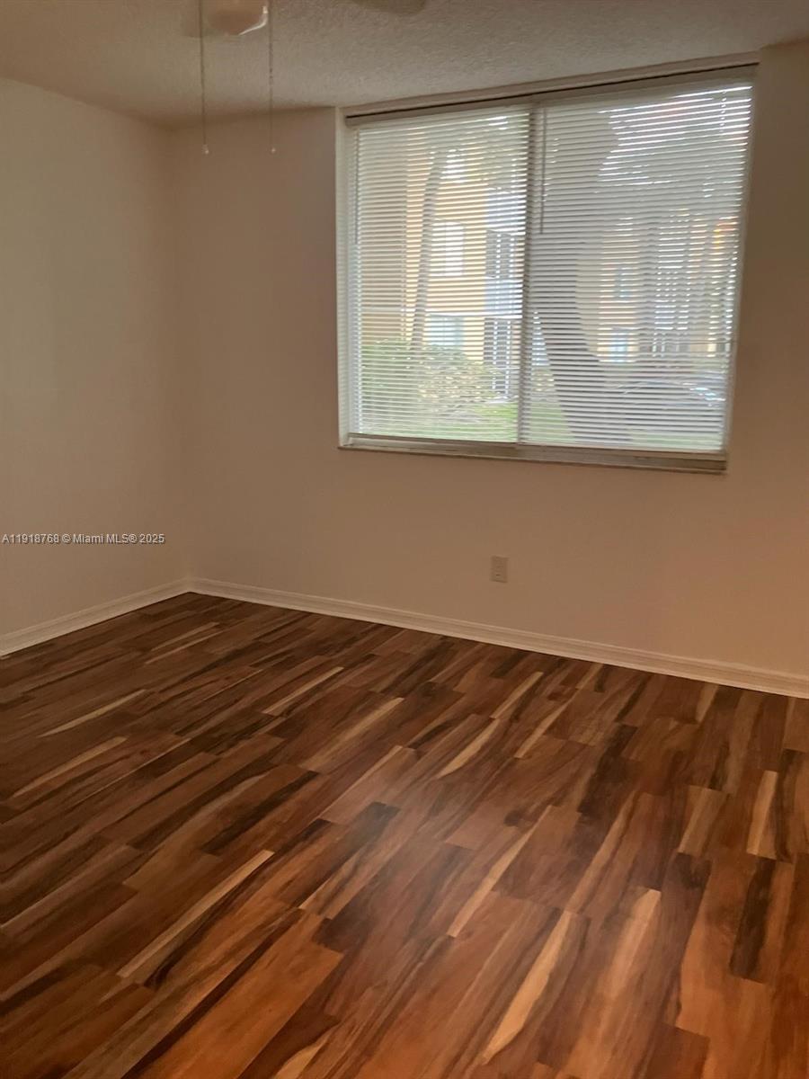 4025 West McNab Road, Unit E105 Pompano Beach, FL 33069 - Photo 6 of 9 a view of a room with wooden floor and a window