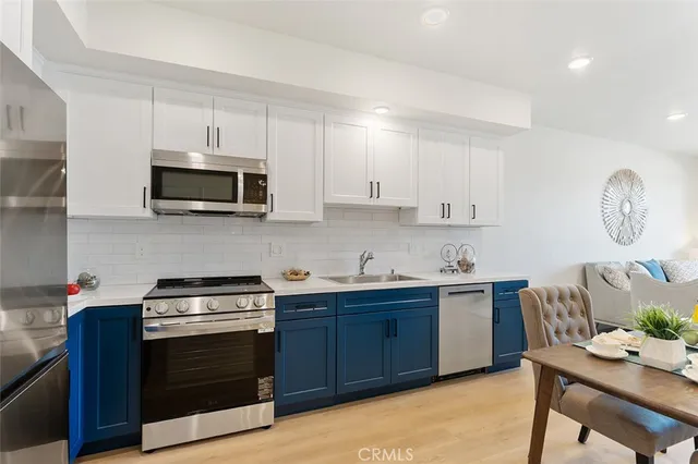 a kitchen with stainless steel appliances granite countertop a stove top oven a sink dishwasher and a microwave oven on the blue kitchen countertops