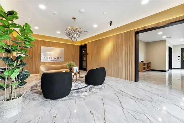 a living room with furniture potted plant and a chandelier