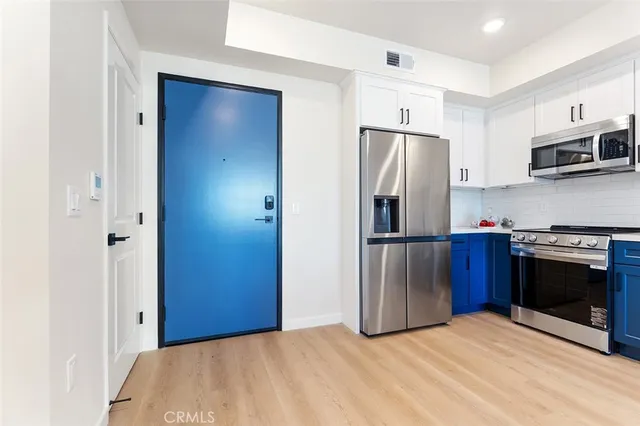 a kitchen with stainless steel appliances granite countertop a refrigerator and a stove