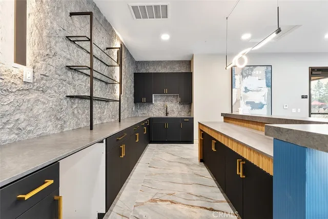 a large kitchen with stainless steel appliances kitchen island granite countertop a sink and a stove