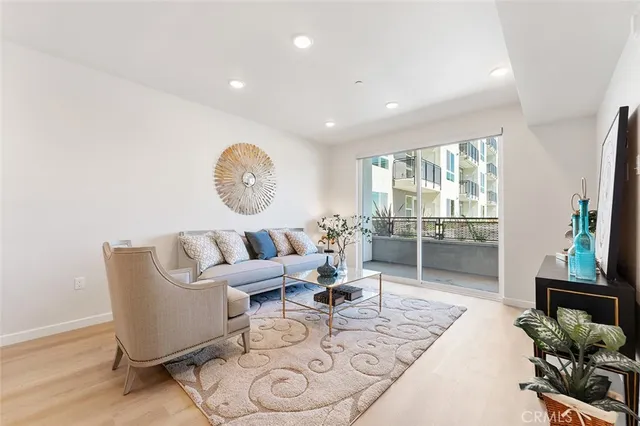a living room with furniture a large window and a wooden floor